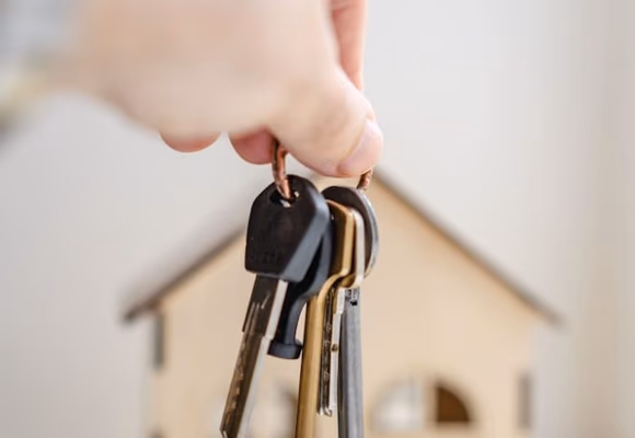 Person holding keys to their first home